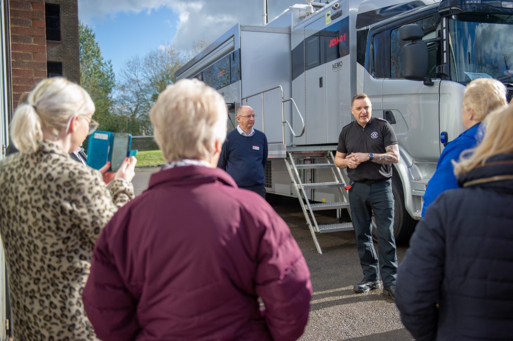 Two staff members talking about the Joint Command Unit to a community group
