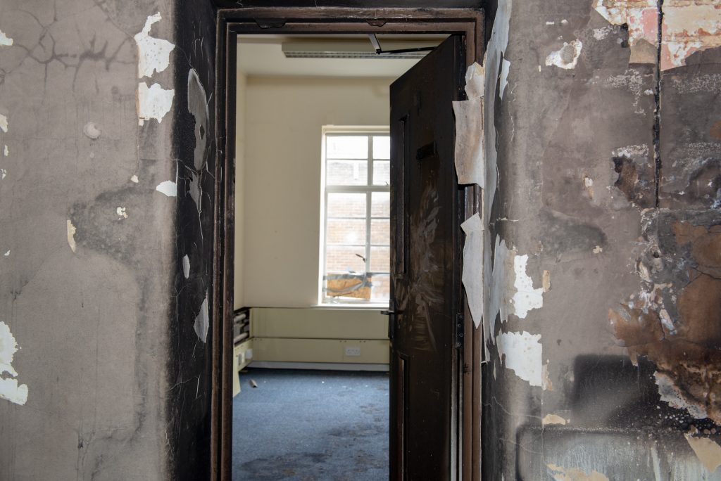 A fire door open at the museum, showing damage on one side and protected walls on the other