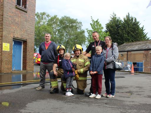 Family with firefighters at the fire station fun day held for families affected by Regent Street fire