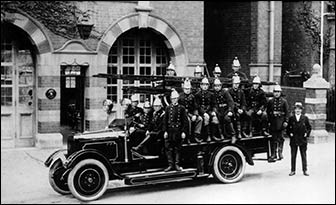 Historical firefighters on old fire appliance