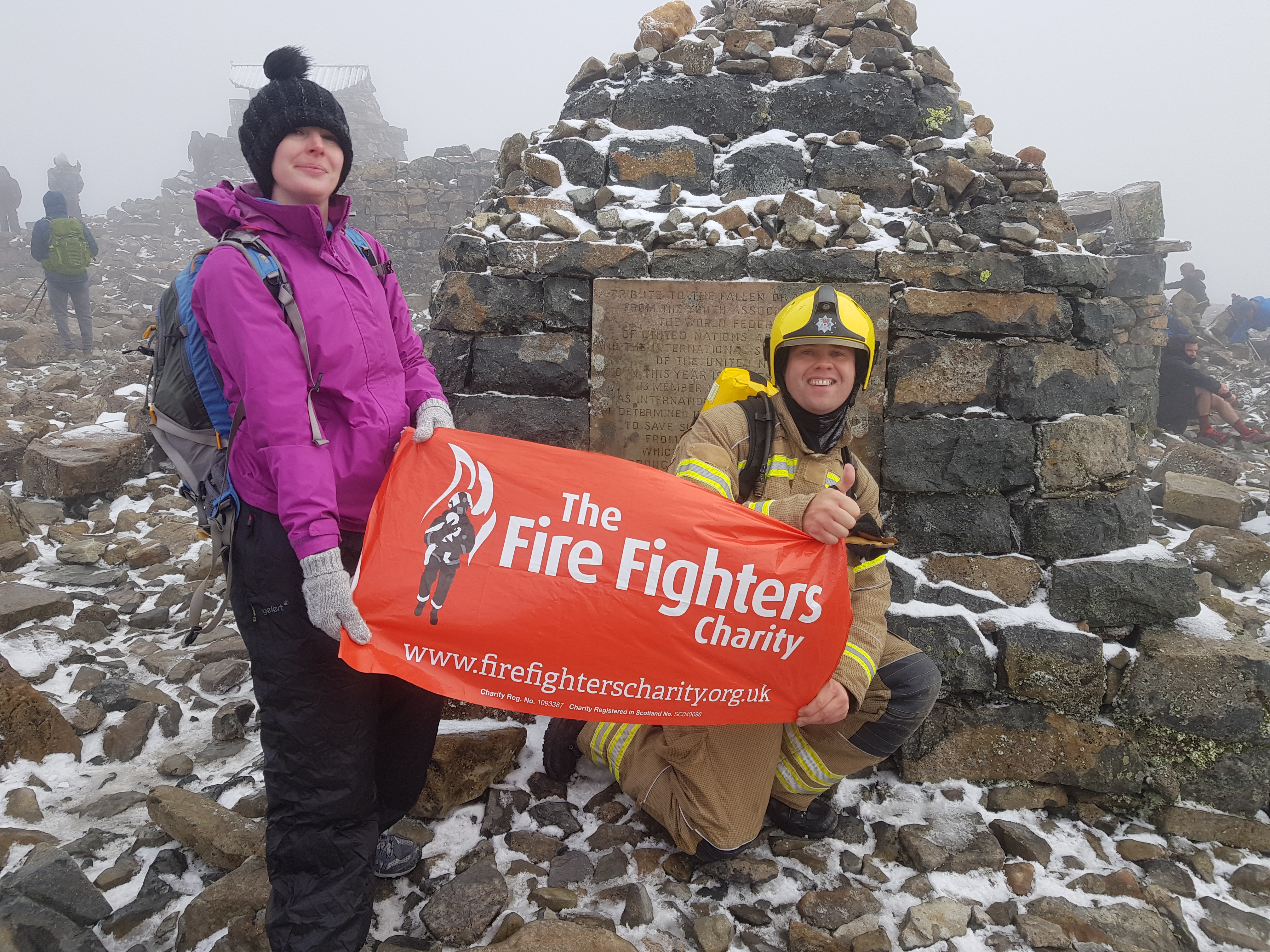 Phil and Michelle Radwell holding a Fire Fighters Charity poster