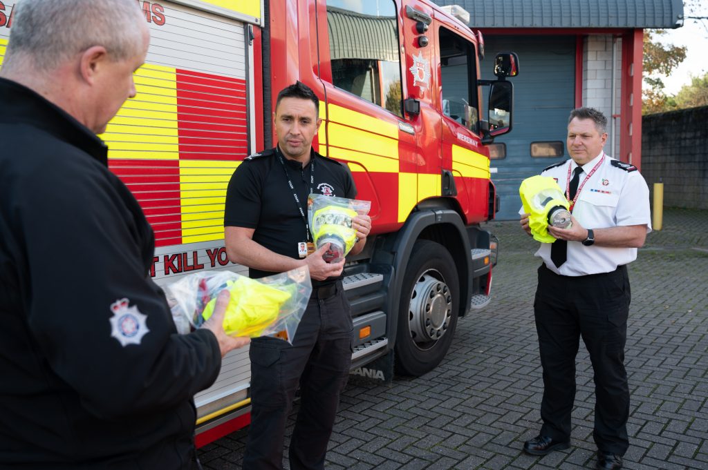 Police Fire and Crime Commissioner Stephen Mold discusses the fire escape hoods with Area Manager Philip Pells and Chief Fire Officer Darren Dovey