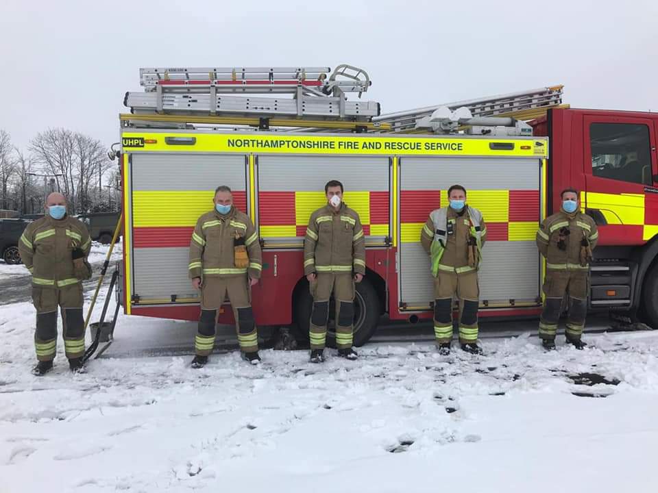 Firefighters from Brackley lined up in front of appliance wearing face masks