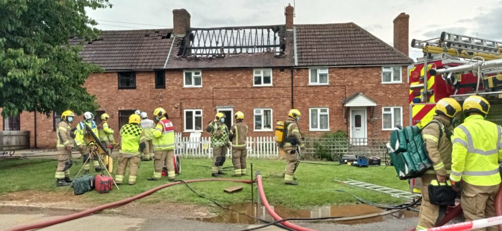 Image of house affected by fire with fire crew