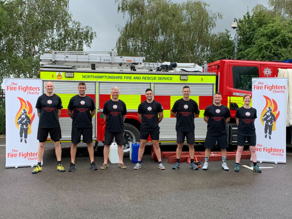 Seven members from Northamptonshire Fire and Rescue Service lined up in firefighter challenge kit