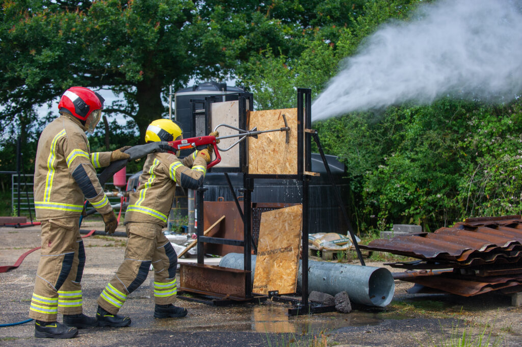 Two firefighters training on ultra high pressure lance equipment