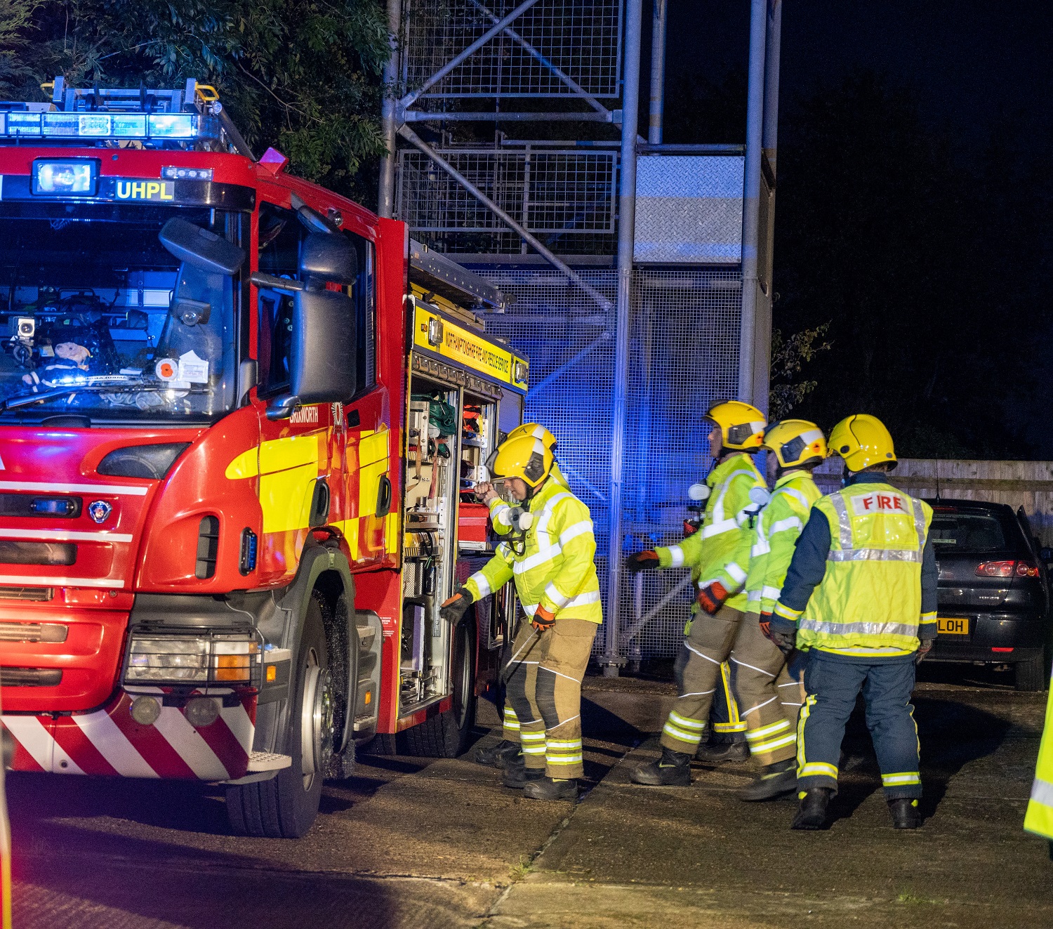 Fire crew getting equipment out of fire appliance