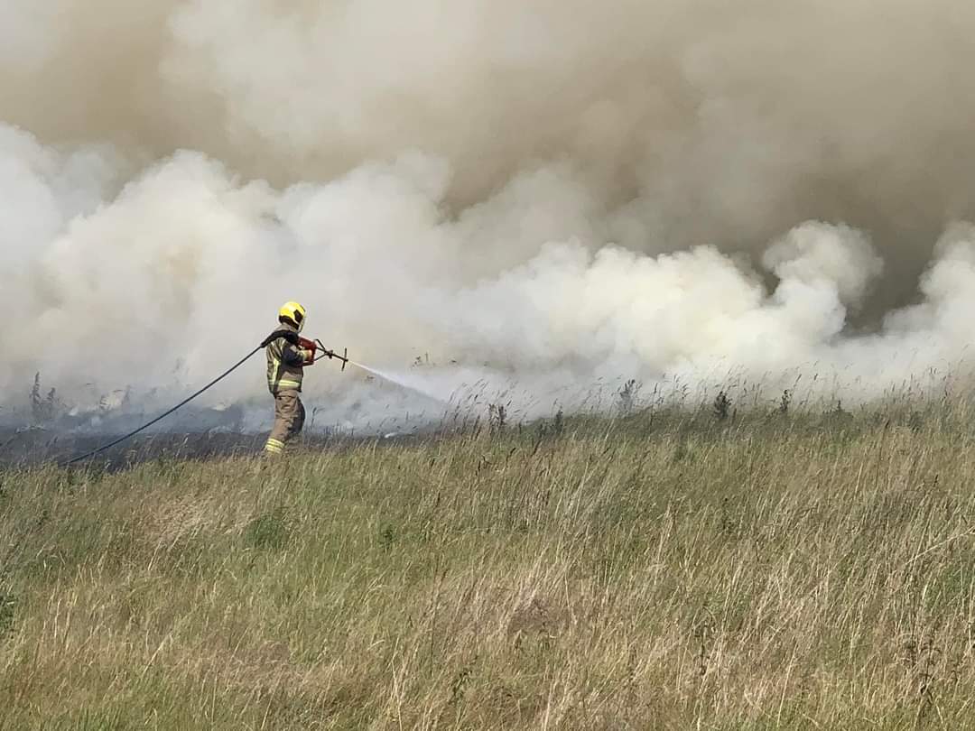 Firefighter tackling a field fire