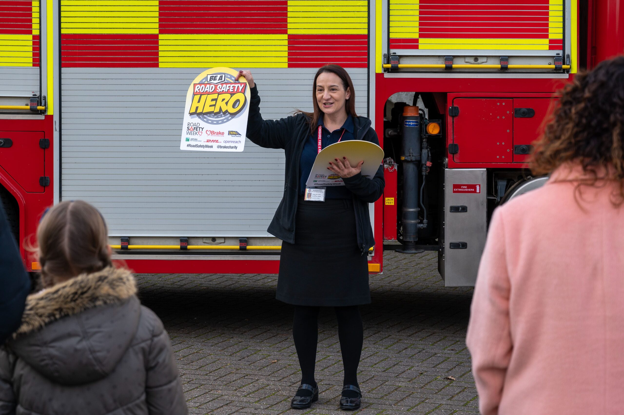 Member of staff showing a road safety campaign poster