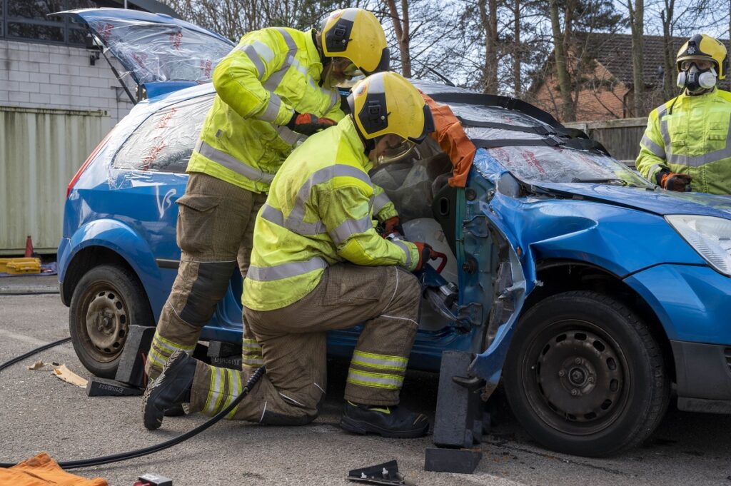 Firefighters cutting casualty out of car