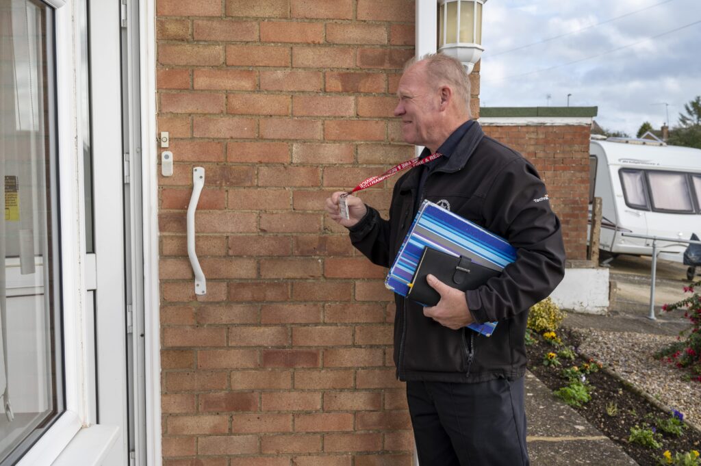 Home Fire Safety Advisor Dave Billing shows his ID badge during a visit to an elderly couple's home