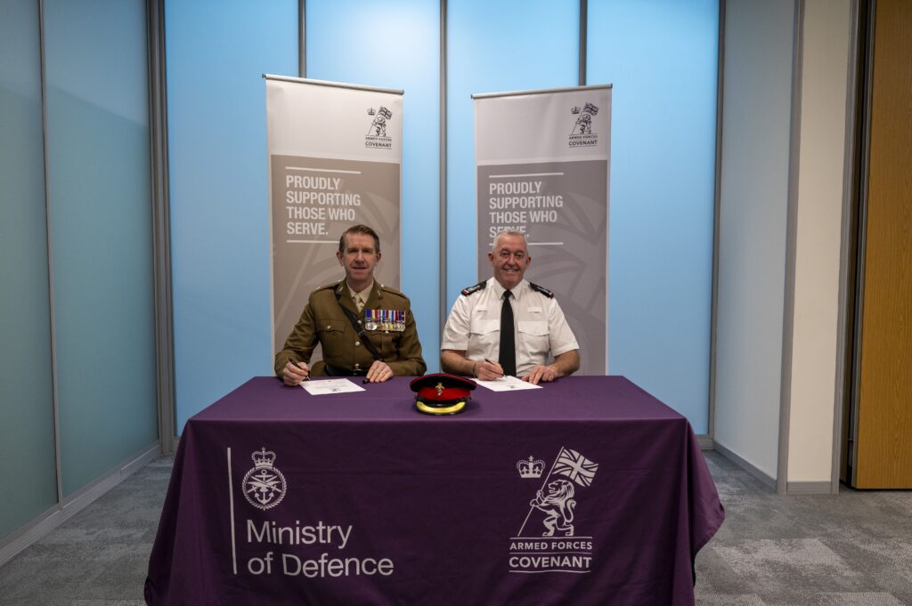 Chief Fire Officer Mark Jones, pictured on the left, signs the Armed Forces Covenant alongside a a representative of the armed forces community