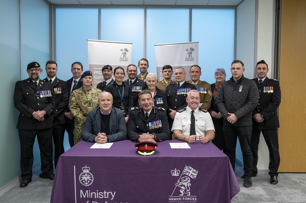 The three men at the front of the picture are Police Fire and Crime Commissioner Stehen Mold on the left, Northamptonshire Police Chief Constable Nick Adderley in the centre, and Chief Fire Officer Mark Jones on the right. Behind them are various armed forces members from Northamptonshire Fire and Rescue Service and Northamptonshire Police.