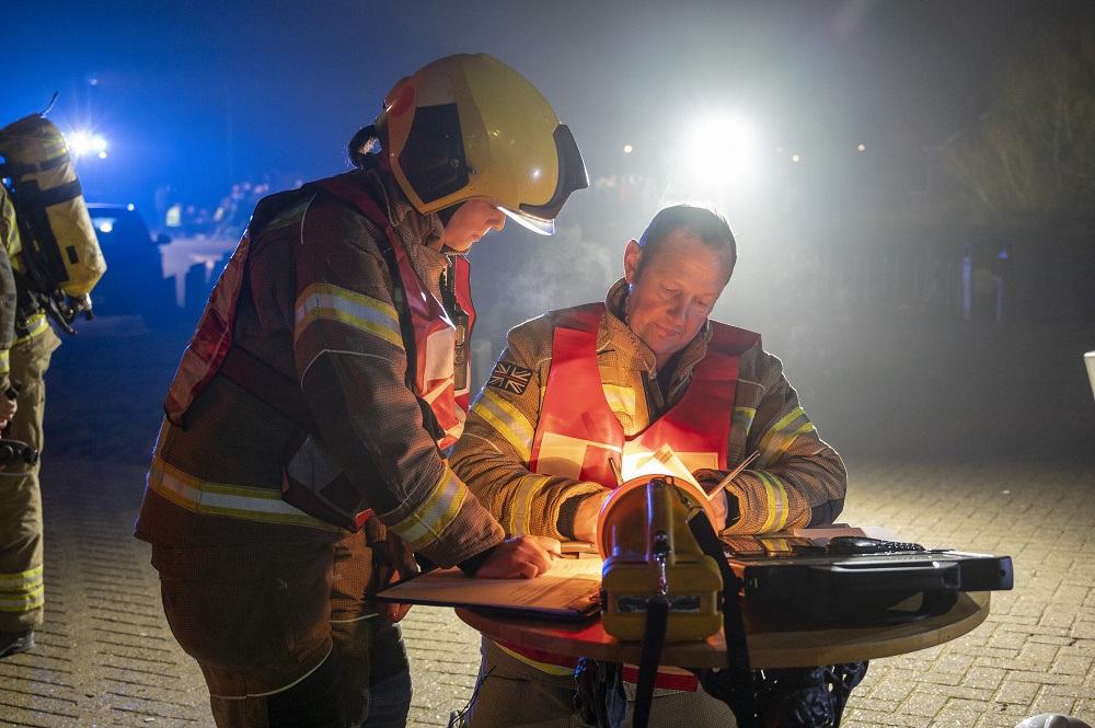 Two firefighters are pictured logging actions during Exercise Curtain Call