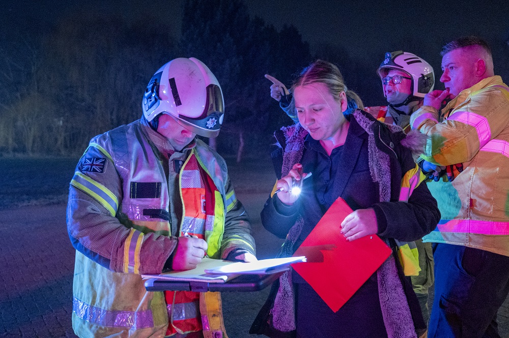 A firefighter on the left and a theatre worker are shown looking at the floor plan of the Lighthouse Theatre in Kettering, where Exercise Curtain Call took place