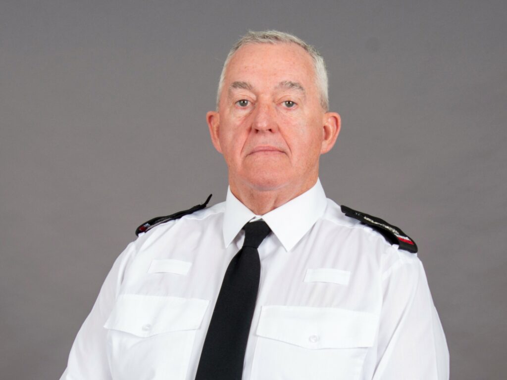 Chief Fire Officer Mark Jones wearing white uniform shirt, black tie and epualettes