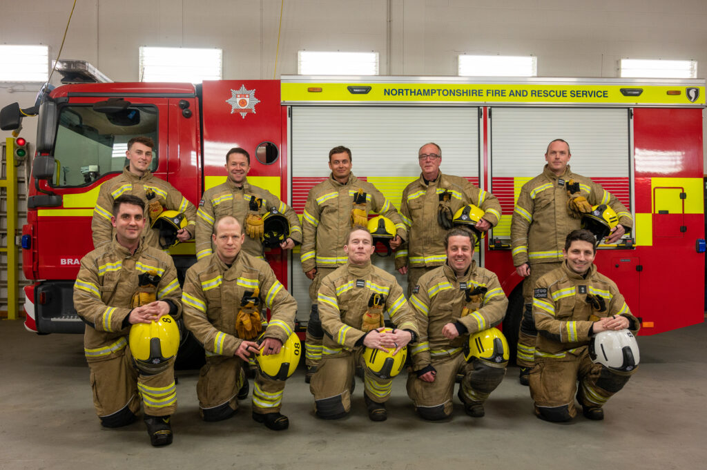 Brackley On Call Crew posing for photo in from of fire engine