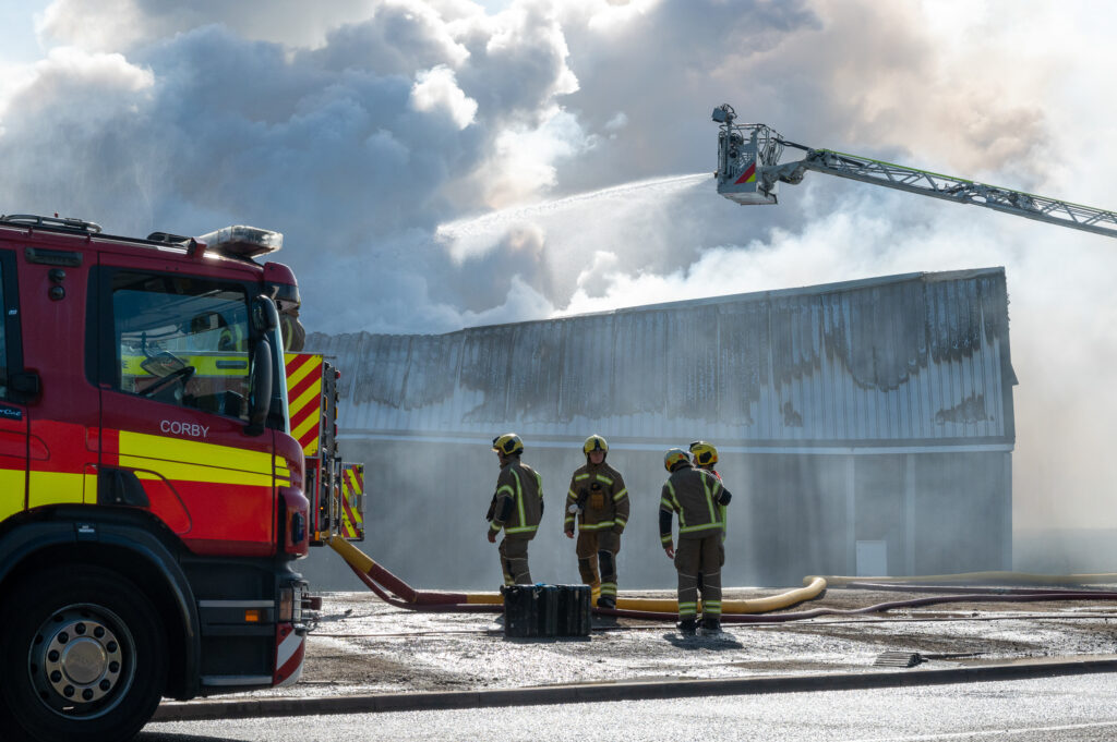 Four firefighters from the Corby crew assess the scene at the fire in Earlstrees Industrial Estate in Corby