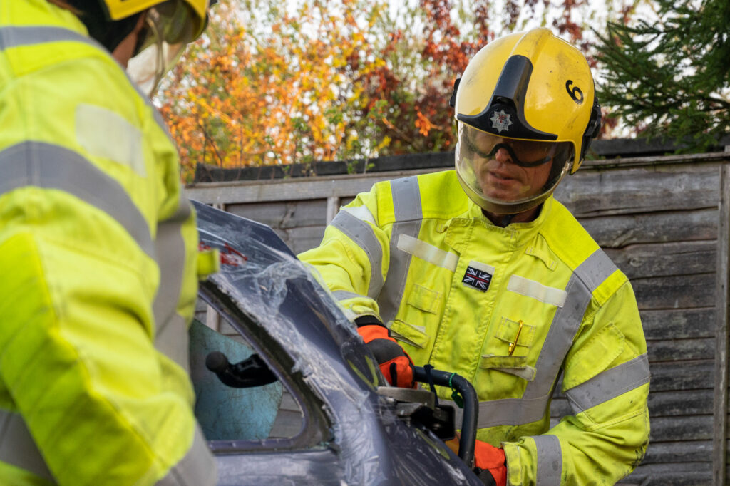 A firefighter cutting up a car 