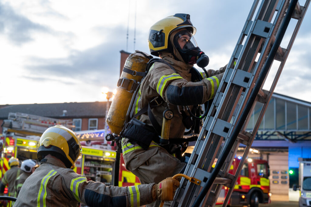 Firefighter in full BA climbing up ladder