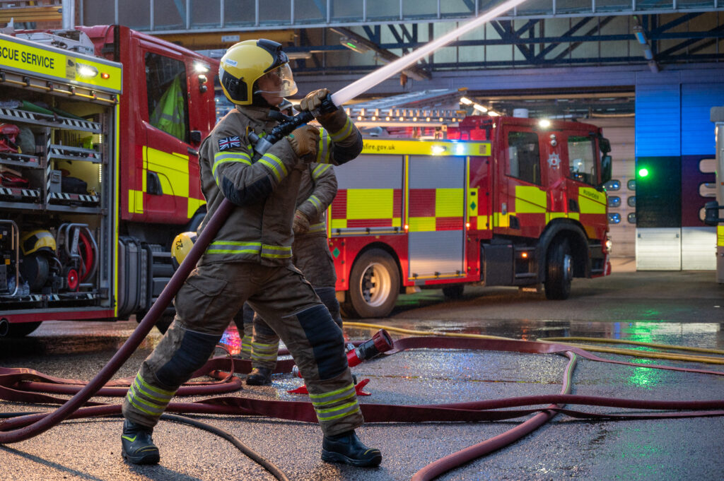 Firefighter using hose in training drill 