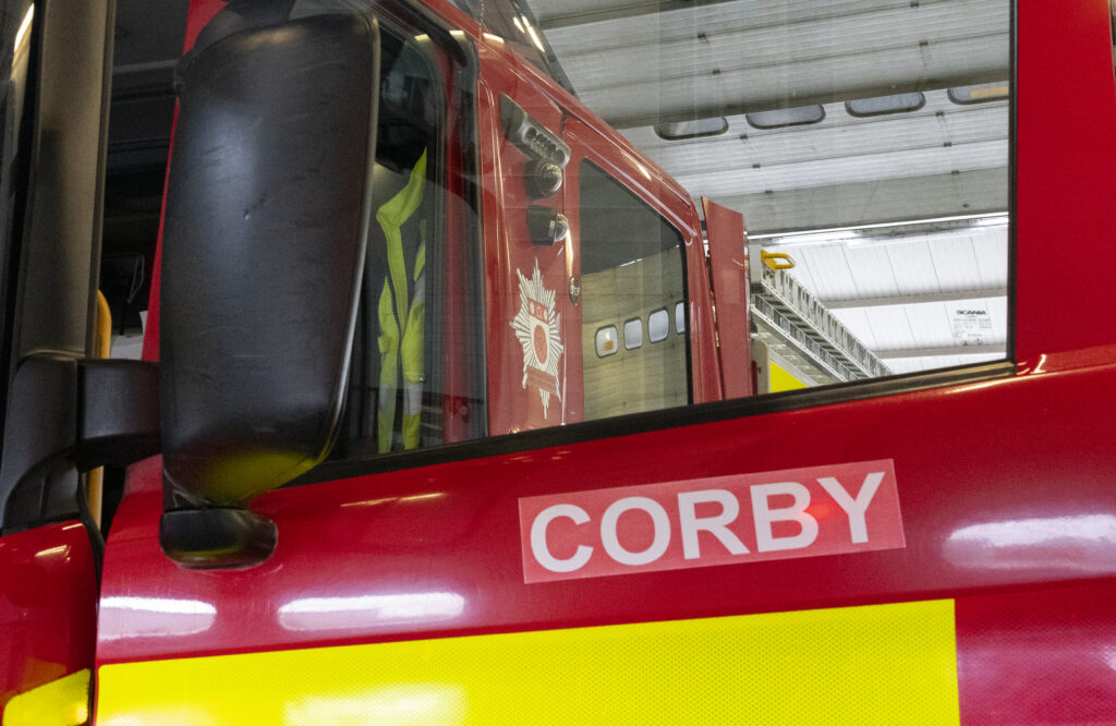 The word Corby is spelt in white letters on the side of the red fire engine