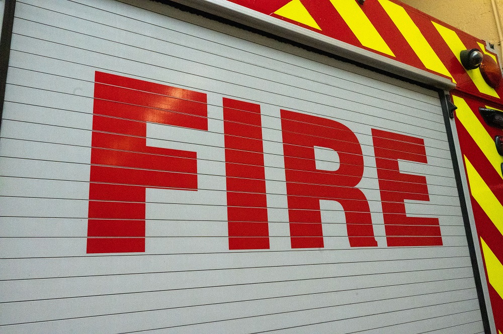 The word fire is spelt out in big red letters on the side of a fire engine