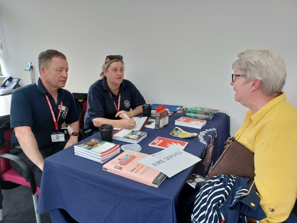 Two Fire Service Prevention Officers speaking with a lady about Home Fire Safety Visits