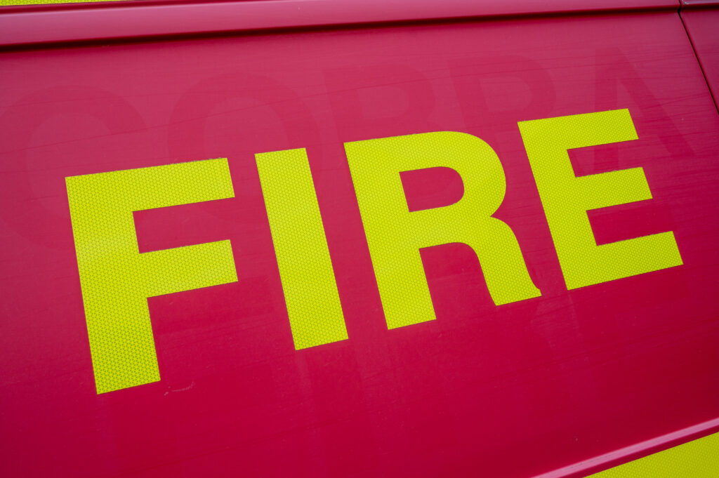 The word FIRE written in yellow on a red fire van