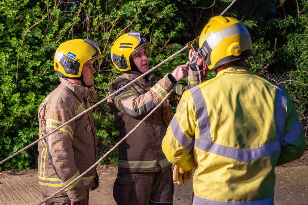 Three firefighters carry out rope work at their drill night