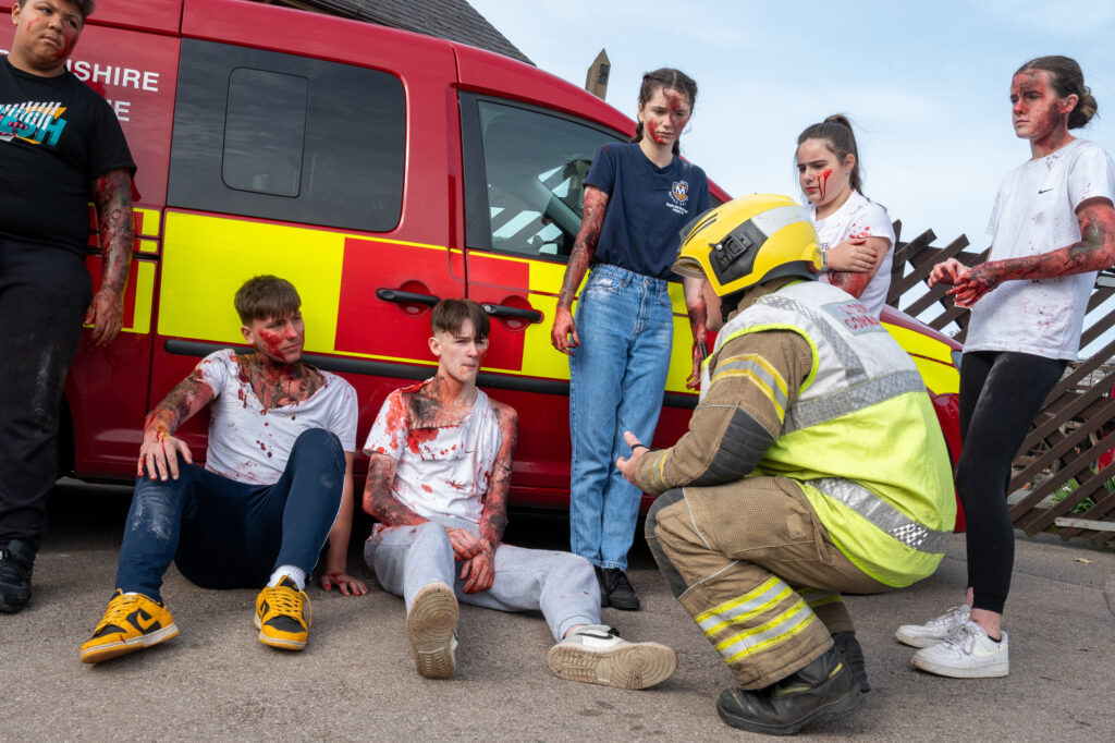 A firefighter speaking to a group of casualties