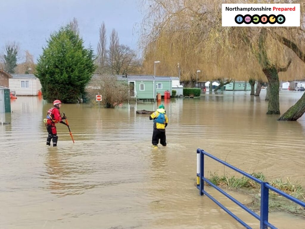 2 people in bright all weather protective uniform conducting a search in flood water