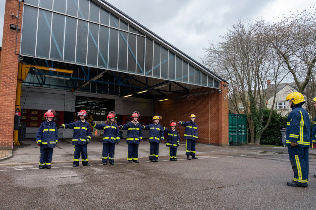 Seven young people dressed in fire kit during a drill