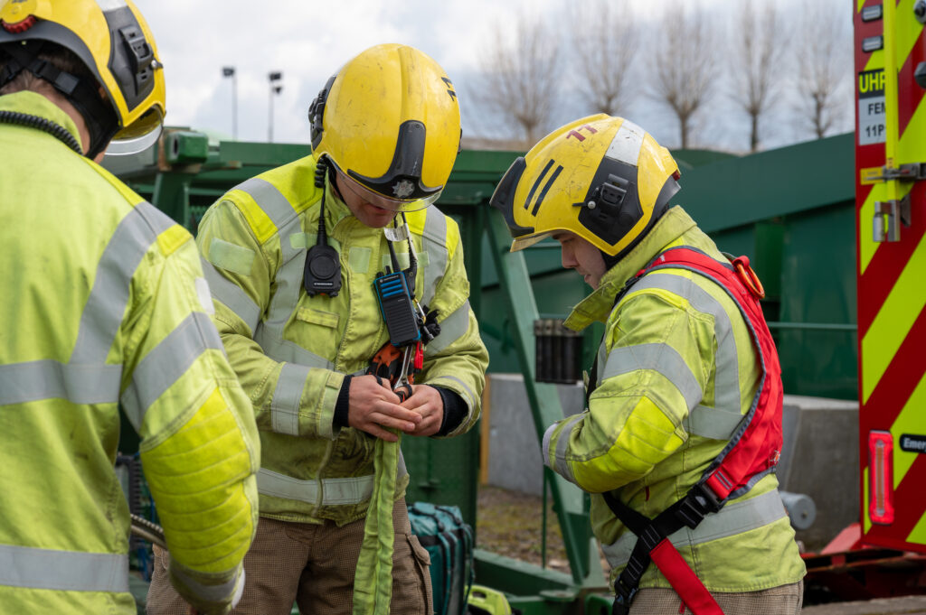 Two firefighters donning fire kit