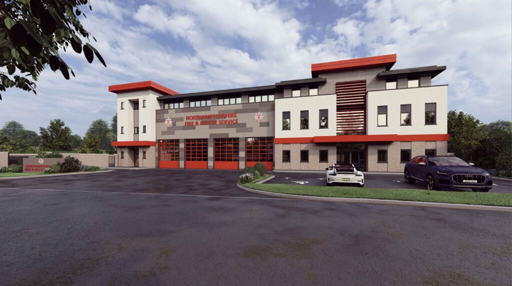 Modern fire station building labeled 'Northamptonshire Fire & Rescue Service' with large windows, red accents, and multiple garage doors. Two vehicles are parked in front, surrounded by a paved driveway and greenery.