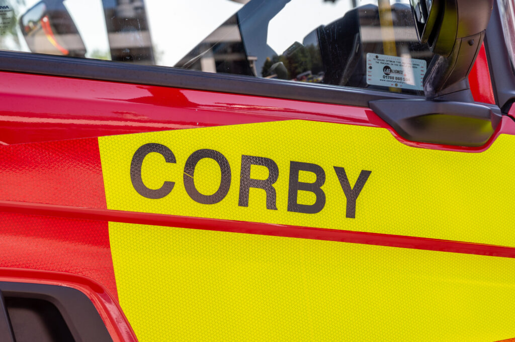 A fire engine door with CORBY in black on it