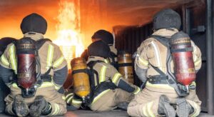 Image of four firefighters wearing BA inside of a container.