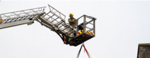 Image of a firefighter on the elevated platform of the Aerial Appliance